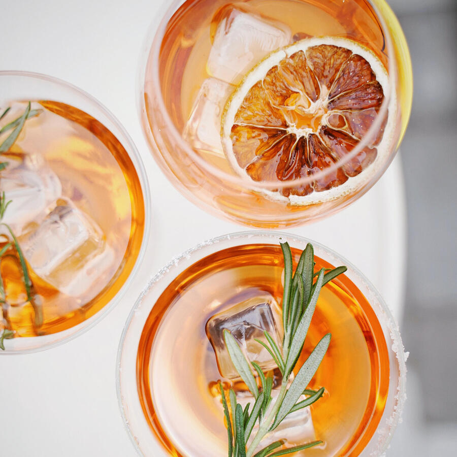 A birds eye view of three orange cocktails in glasses